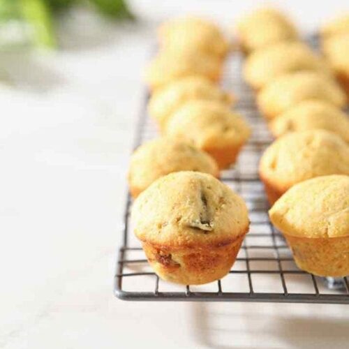 Several Hatch Chile Mini Cornbread Muffins are lined up on a cooling rack