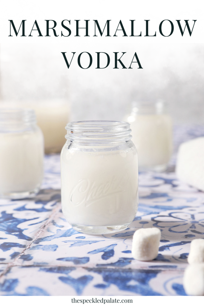 a mason jar of marshmallow vodka on a blue tiled surface with the text marshmallow vodka